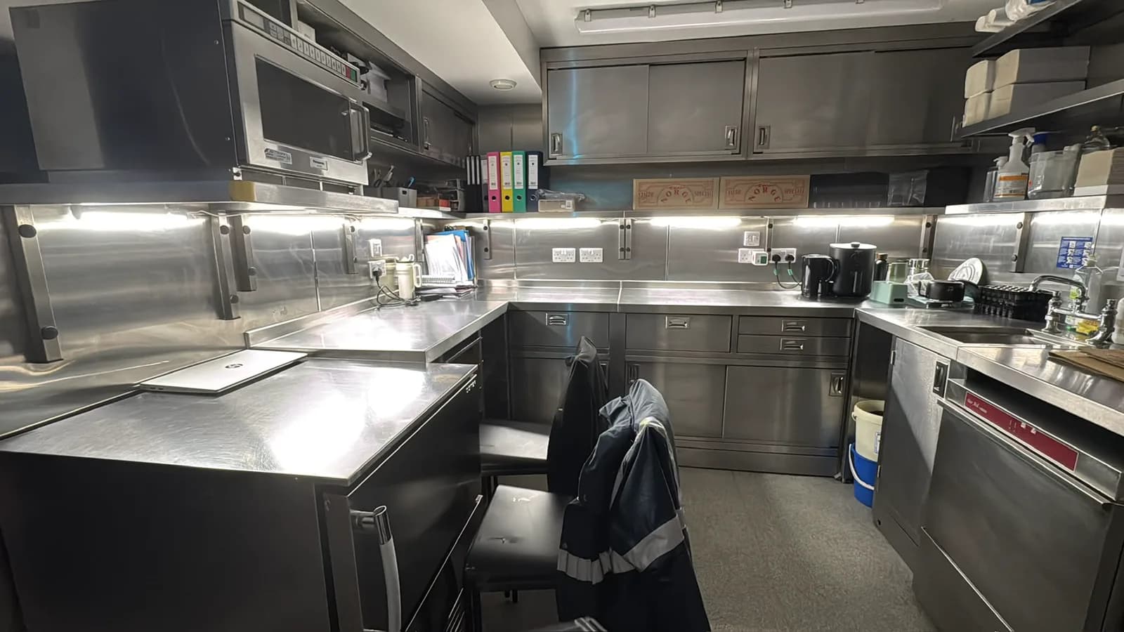 Stainless steel commercial kitchen with under-unit lighting and sockets