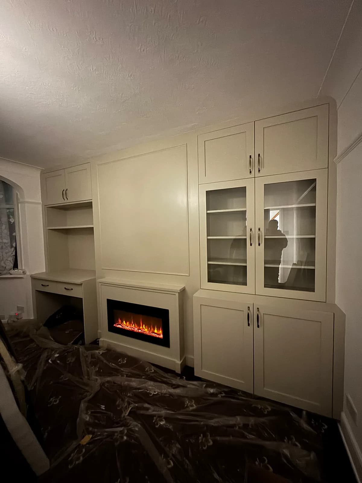 Living room with downlights, a built-in media wall and an electric fire