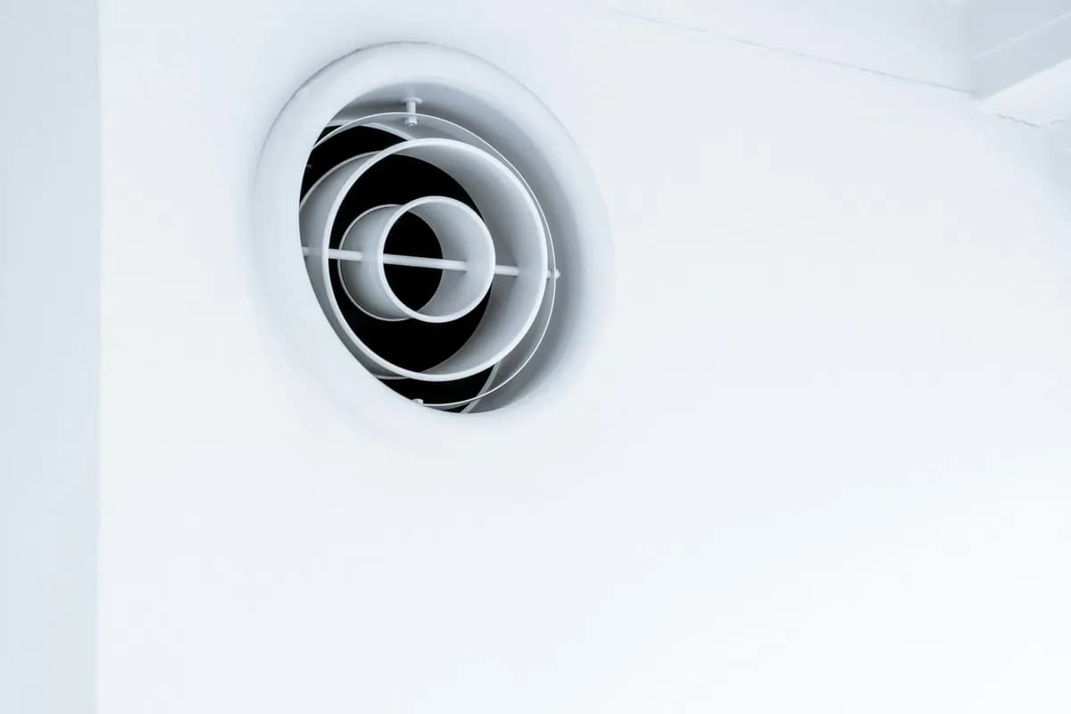 Round white extractor fan set into a wall