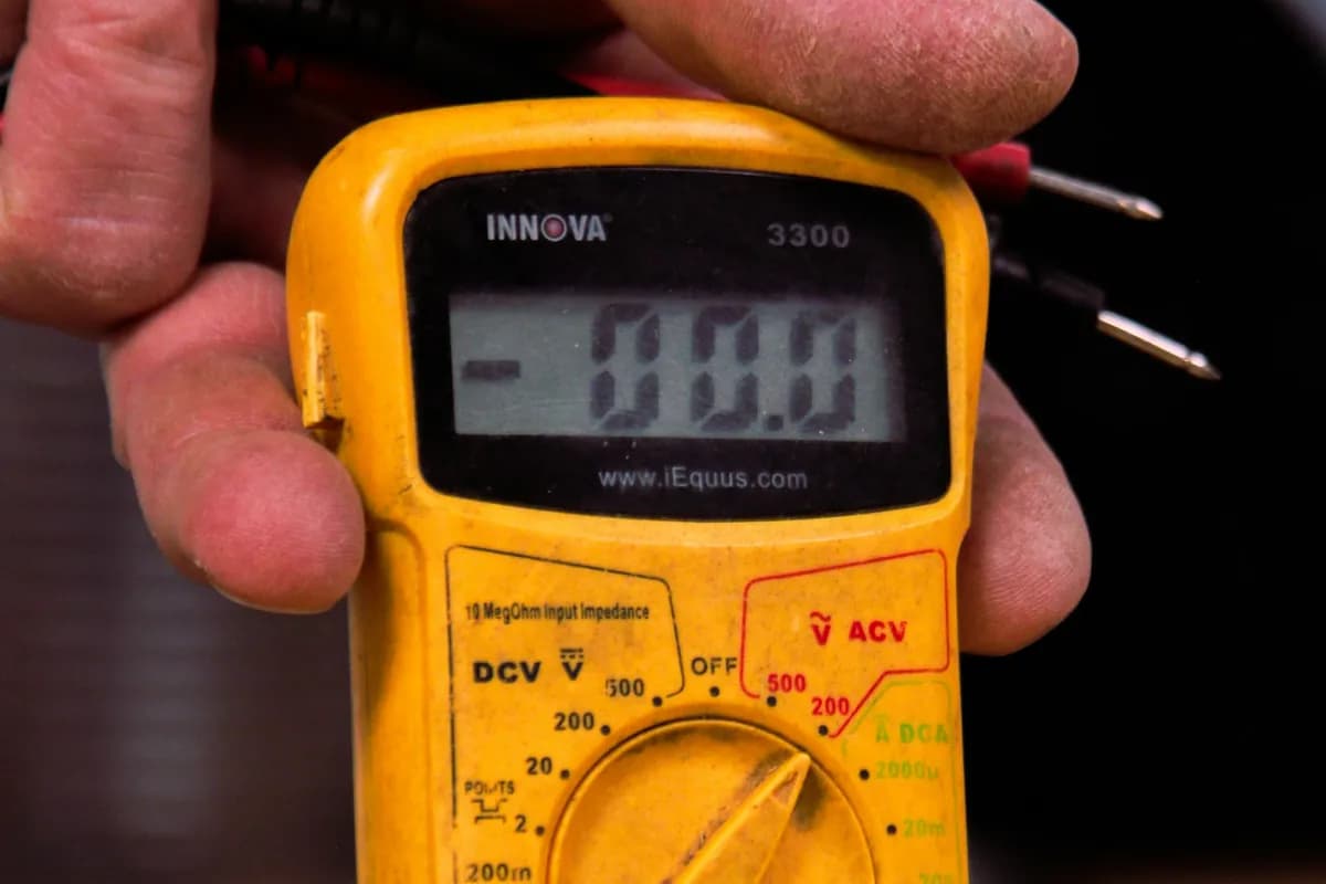 Electrician holding a multimeter while tracing a fault