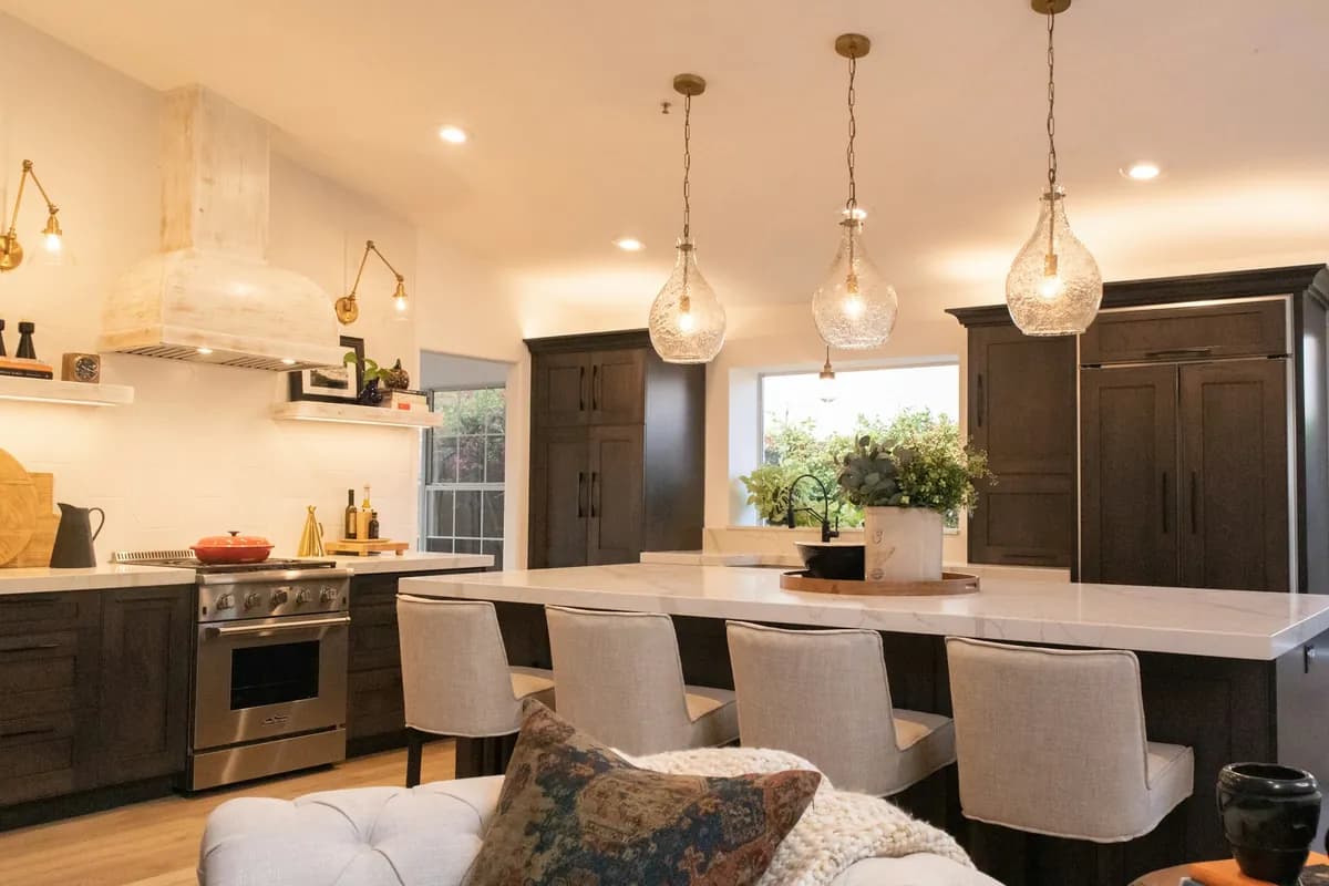 Kitchen with glass pendant lights over the island and recessed downlights