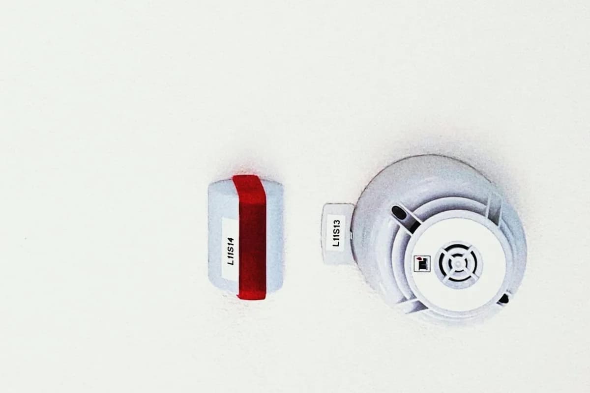Smoke detector and indicator fitted to a white ceiling
